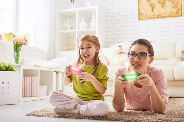Mother and daughter playing video games together Stock Photo