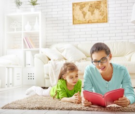 Mother and daughter reading together in the living room Stock Photo 01