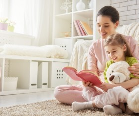 Mother and daughter reading together in the living room Stock Photo 02