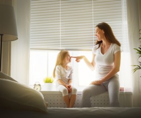 Mother and daughter sitting on the windowsill happy Stock Photo