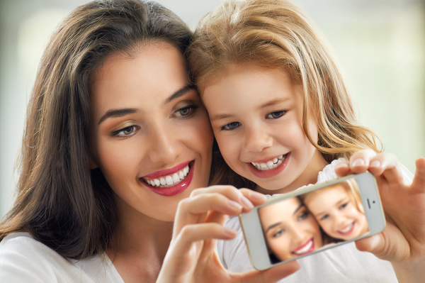 Mother and daughter use a smartphone for selfie Stock Photo