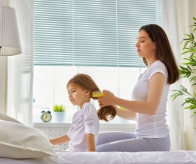 Mother combs hair for daughter Stock Photo