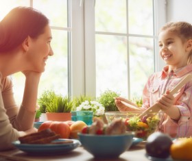 Mother looks at the daughter who makes the salad Stock Photo