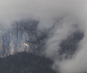 Parachute flying on thick cloudy mountain landscape Stock   Photo