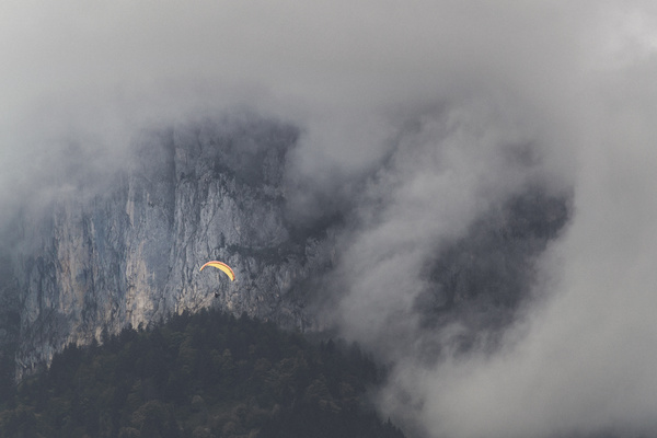 Parachute flying on thick cloudy mountain landscape Stock   Photo