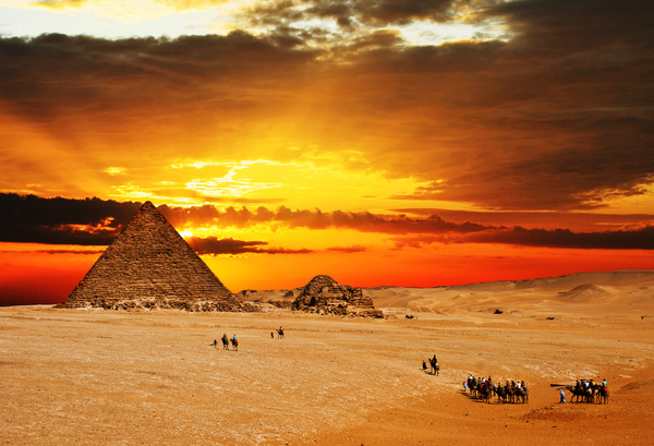 People traveling by camel to visit pyramids Stock Photo