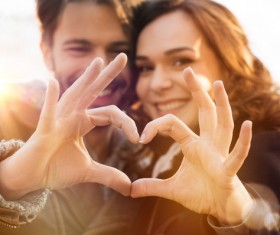 Romantic lovers make heart gesture Stock Photo