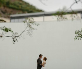 Romantic marriage couple posing near white wall Stock Photo