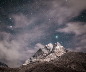 Sparkling starry sky above rocky mountain Stock Photo