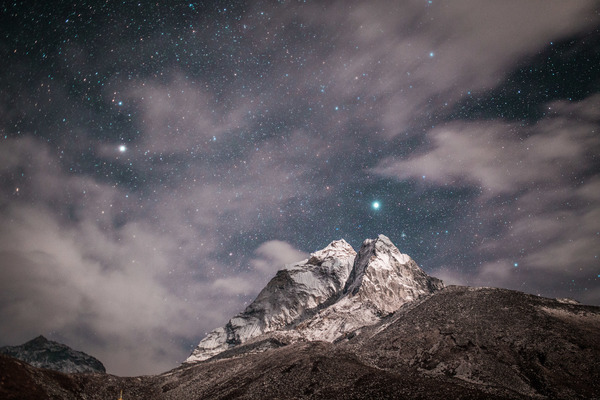 Sparkling starry sky above rocky mountain Stock Photo