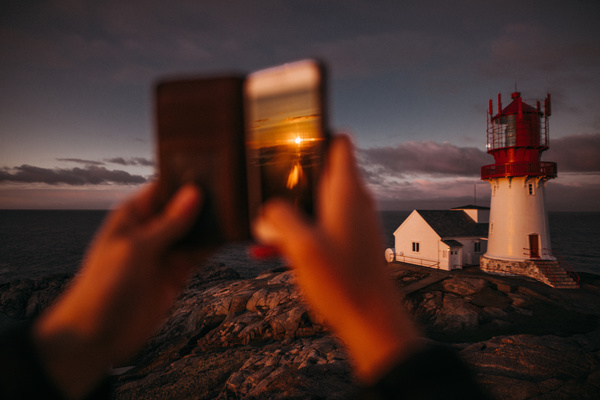 Taking photo of lighthouse with smartphone Stock Photo