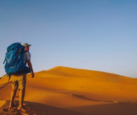 Traveler walking in the desert Stock Photo