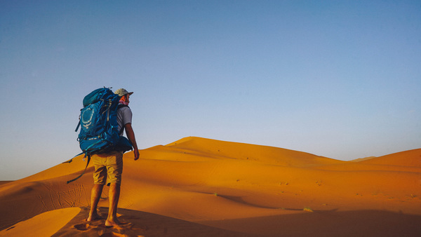 Traveler walking in the desert Stock Photo