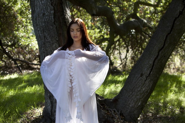 Woman in white dress meditating in the woods Stock Photo