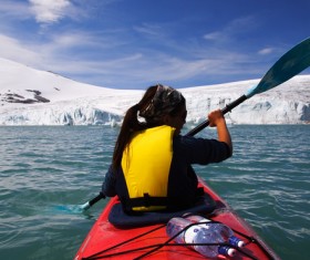 Woman in winter paddling boat Stock Photo