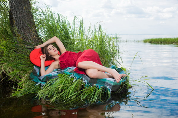Woman lying relaxed by the river Stock Photo