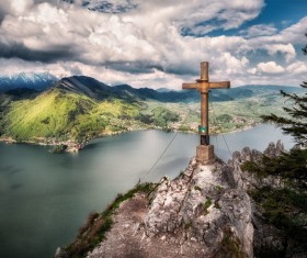 Wooden cross on high rocky peak landscape Stock Photo