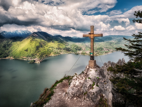 Wooden cross on high rocky peak landscape Stock Photo