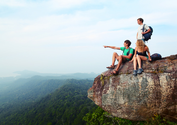 Young climber sitting on the mountain top Stock Photo