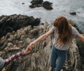 Young couple walking on rocky beach Stock Photo
