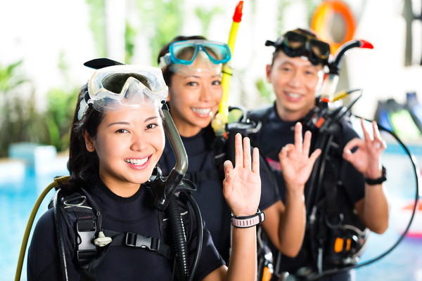 Young people dressed in diving suits Stock Photo