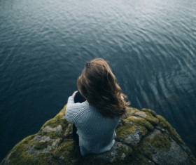 Young woman looking at calm lake Stock Photo