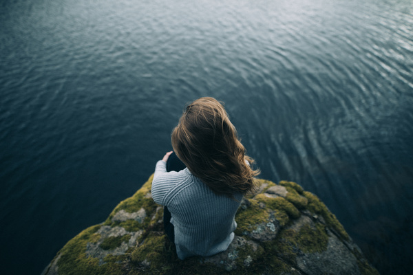 Young woman looking at calm lake Stock Photo