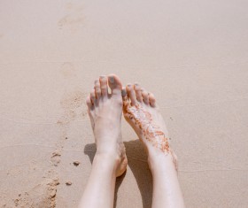 woman legs relaxed on sea sand Stock Photo