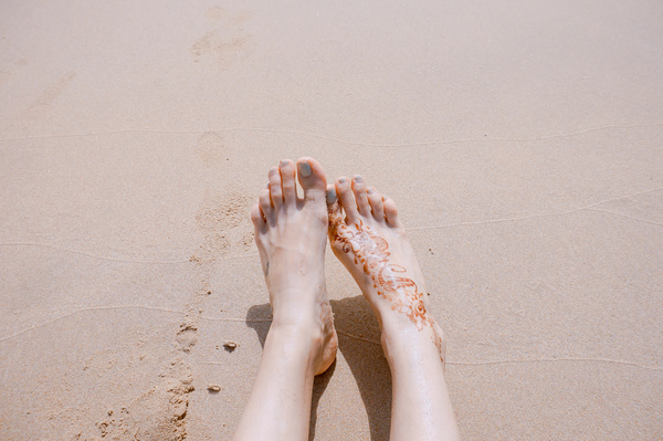 woman legs relaxed on sea sand Stock Photo