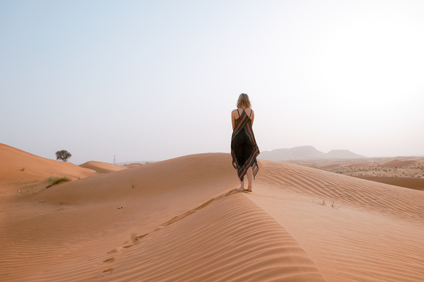 woman walking on dunes desert Stock Photo