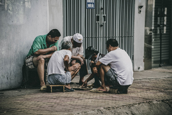 Asian men playing chess on pavement Stock Photo