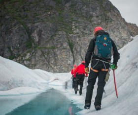Backpacker walking on iceberg Stock Photo