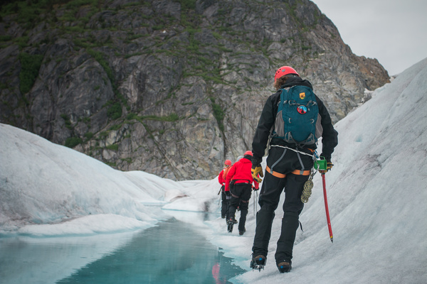 Backpacker walking on iceberg Stock Photo