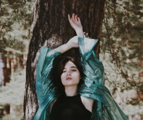 Beautiful asian girl leaning on tree trunk Stock Photo