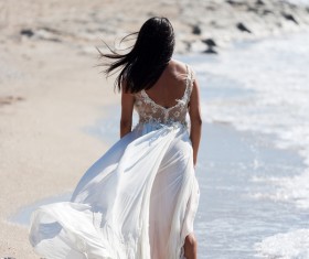 Bride walking on the beach Stock Photo