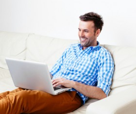 Casual man relaxing using laptop Stock Photo 02