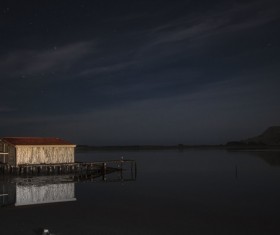Cottage on calm river at twilight Stock Photo
