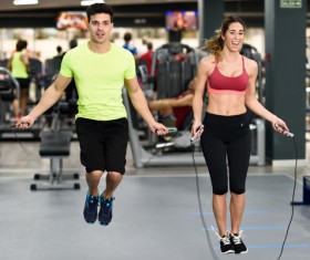 Couple doing jump rope exercises in gym Stock Photo