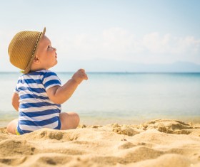 Cute little boy sitting on the beach Stock Photo