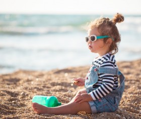 Cute little girl sitting on the beach Stock Photo