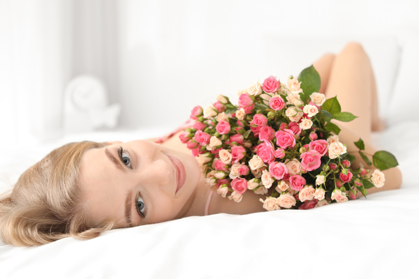Girl in bed holding rose flower in bed Stock Photo 03