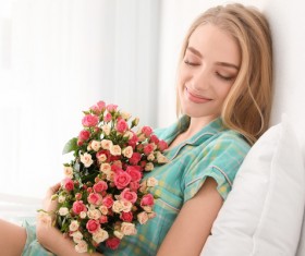 Girl sitting in bed holding a rose flower Stock Photo 02