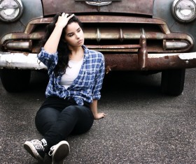 Girl sitting in front of old car Stock Photo