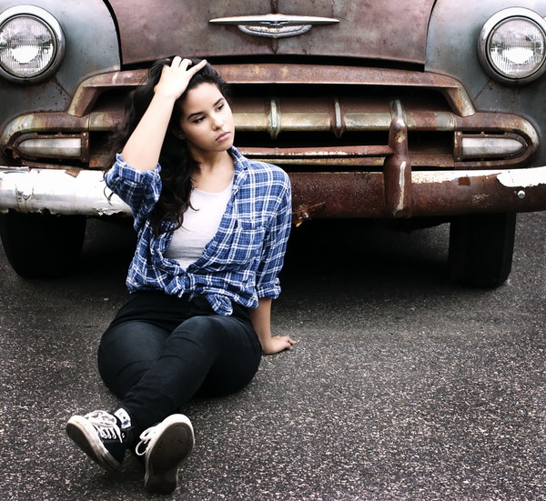Girl sitting in front of old car Stock Photo