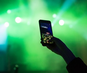 Hand taking photo with smartphone in music party Stock Photo