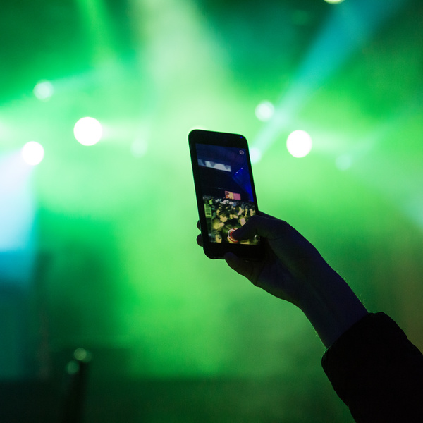 Hand taking photo with smartphone in music party Stock Photo