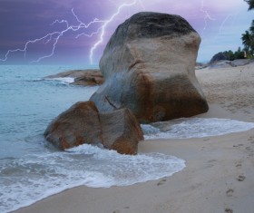 Lightning with seaside boulders landscape Stock Photo