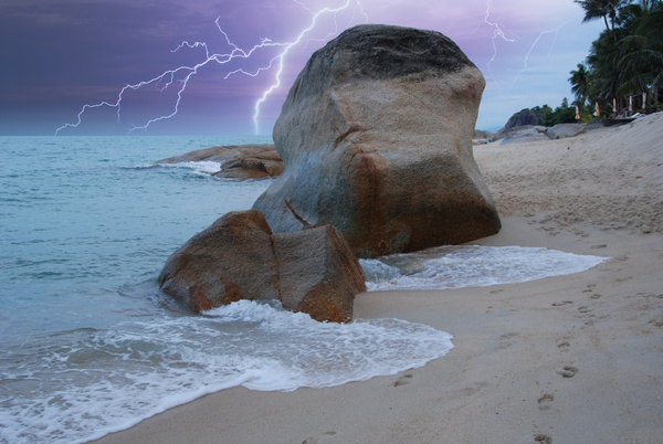 Lightning with seaside boulders landscape Stock Photo