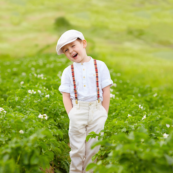 Little boy standing in farmland smiling Stock Photo