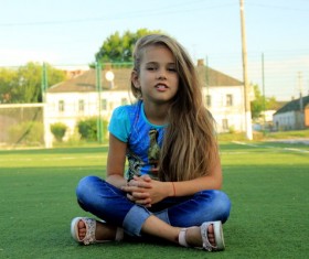 Little girl sitting on the lawn Stock Photo